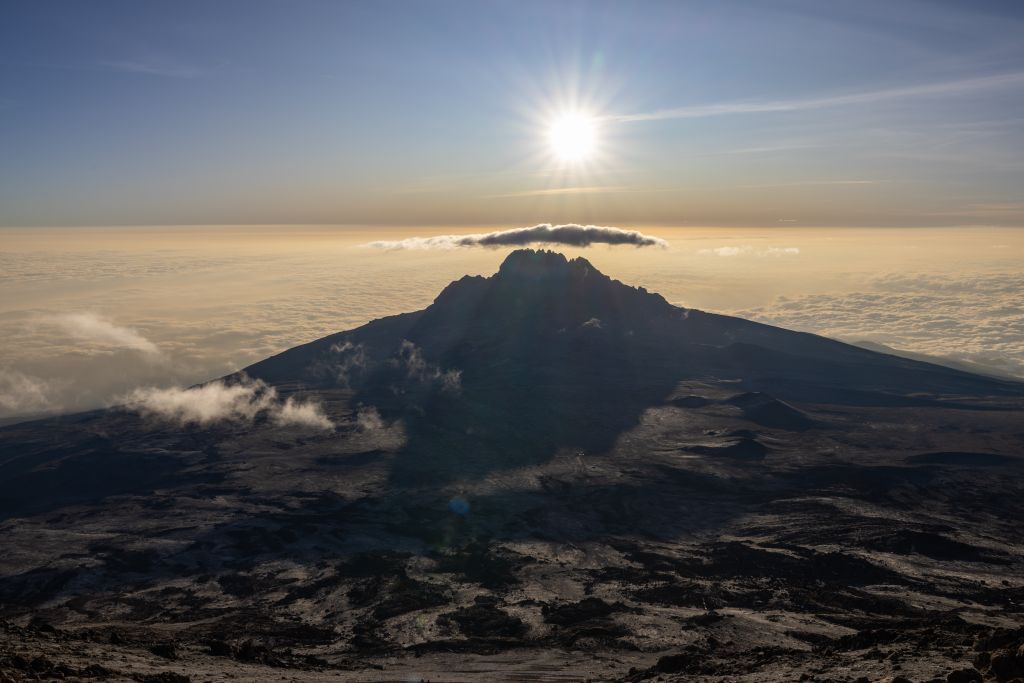 Breathtaking view of Mount Kilimanjaro at sunrise with the sun casting a perfect silhouette.